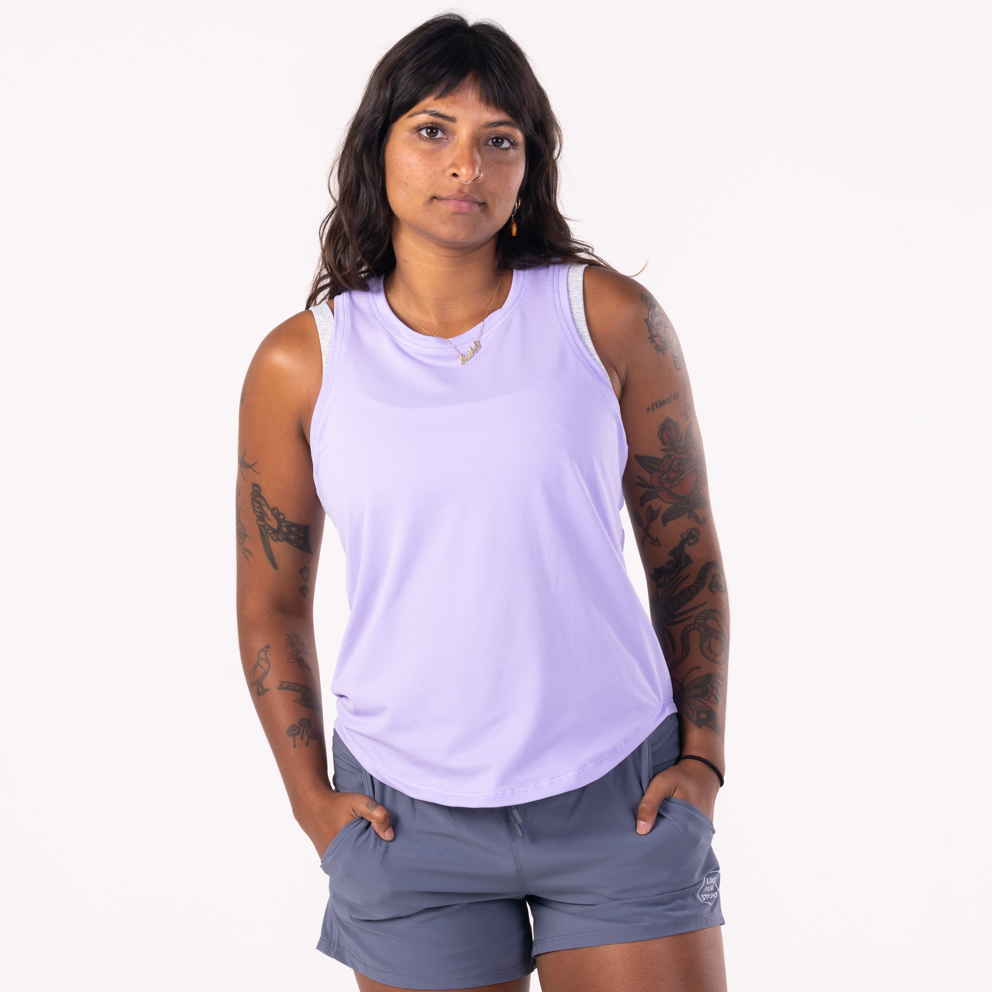A woman wearing a lilac LIVE A GREAT STORY Women's Racer Tank Top