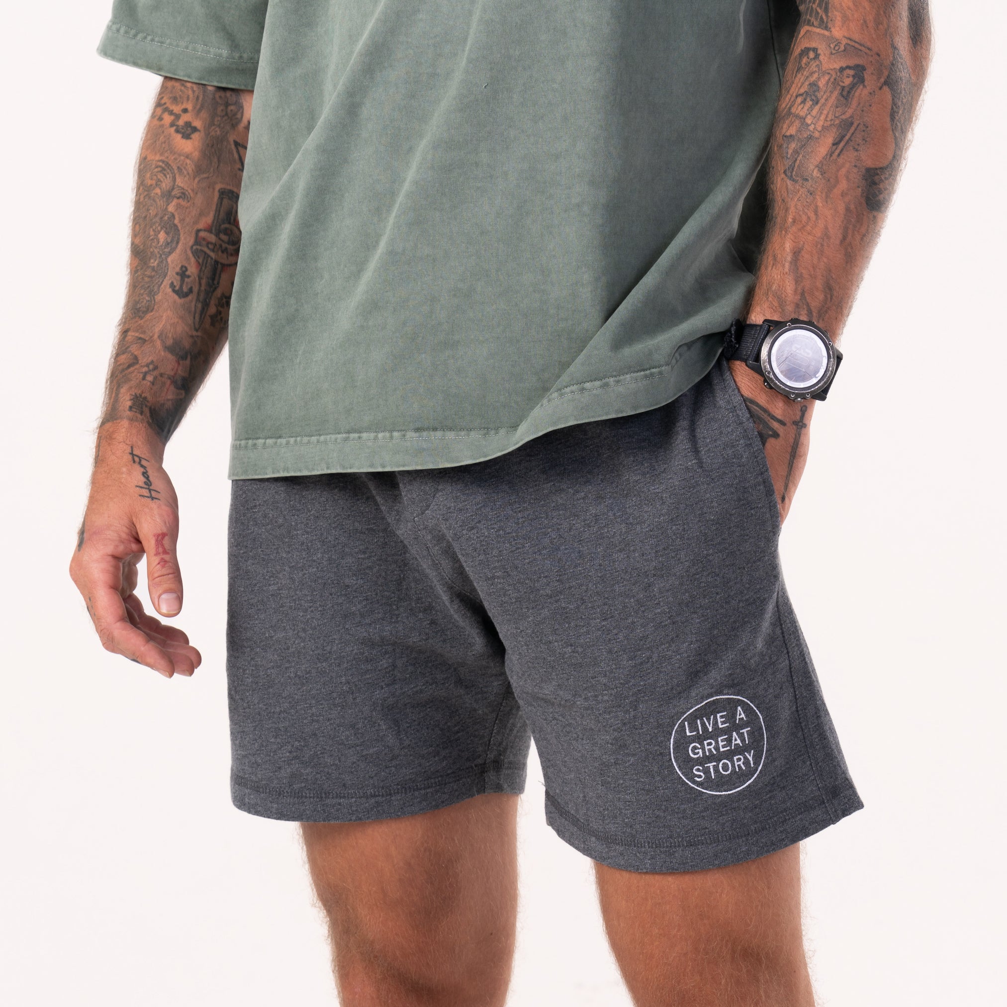 A closeup of a person wearing gray comfortable men's Camp Fire Shorts with their hand in the front pocket