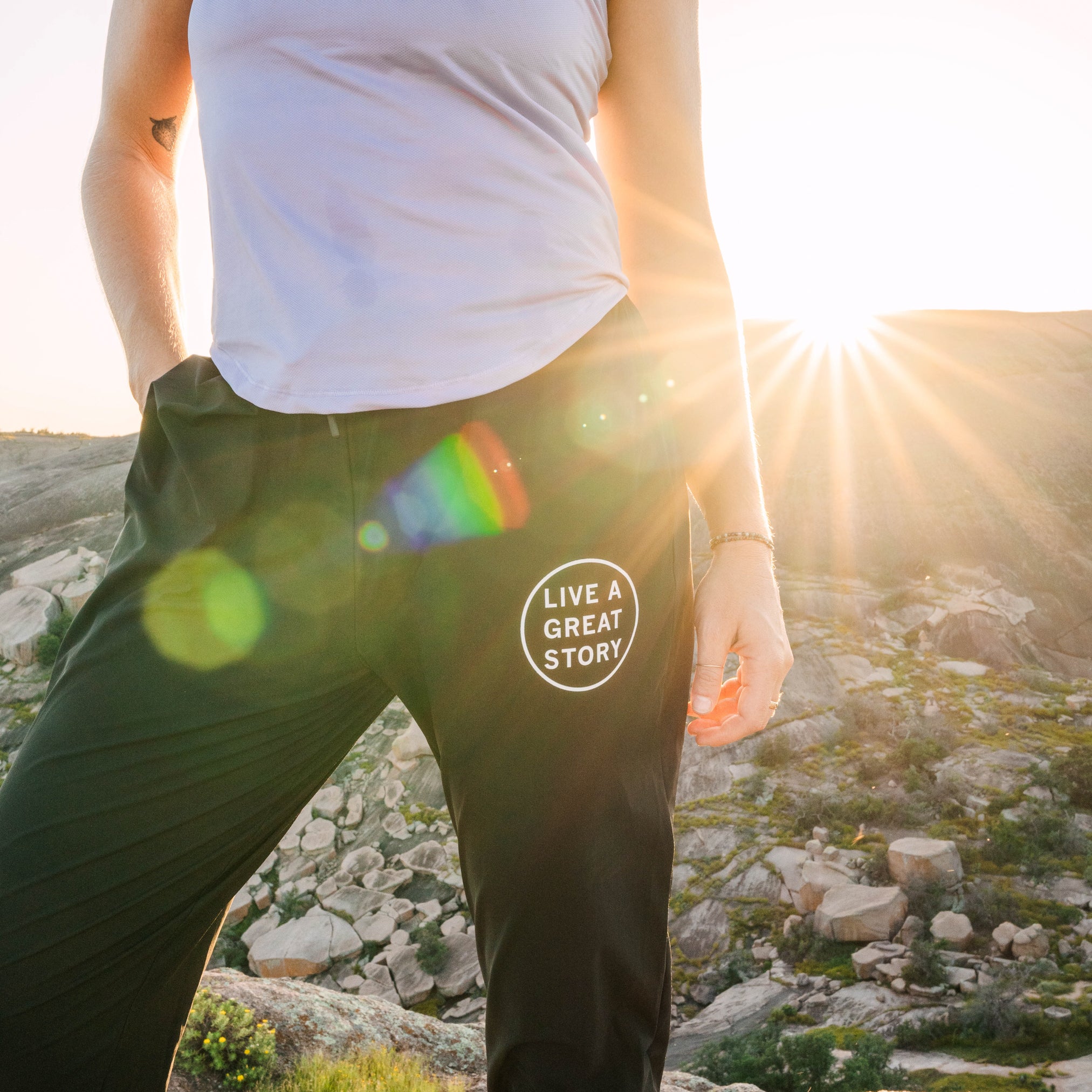 A woman wearing black LIVE A GREAT STORY athletic jogger pants while outside