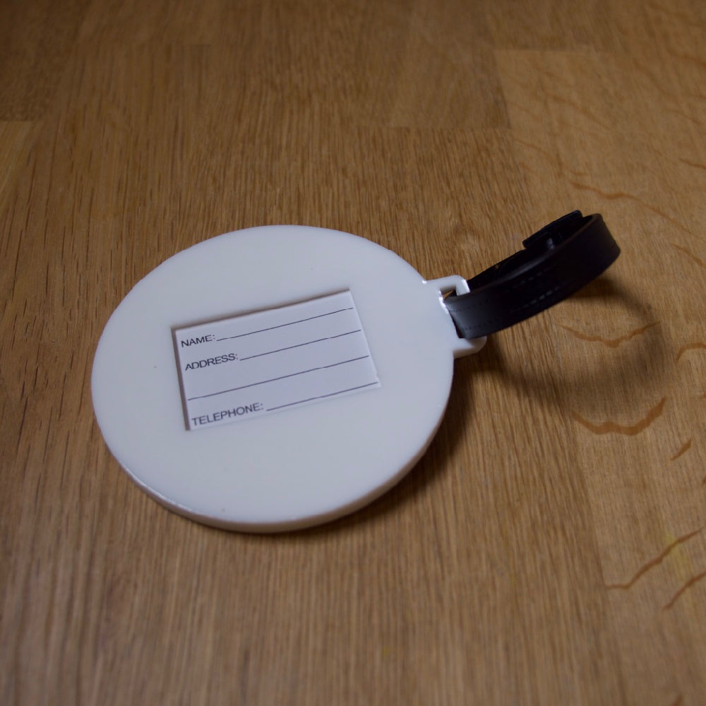 The back view of a LIVE A GREAT STORY luggage tag