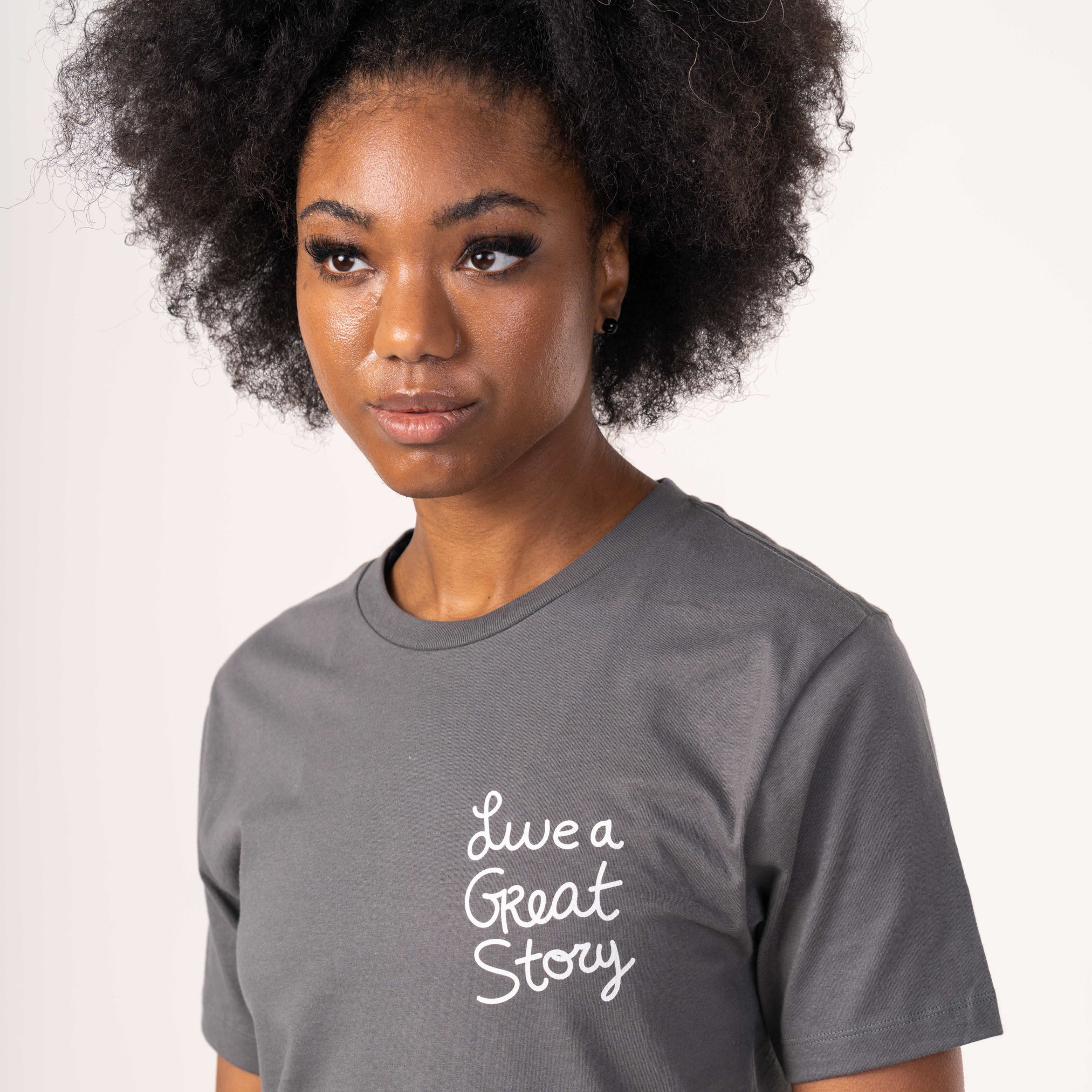 A woman wearing a LIVE A GREAT STORY Original Spray Paint T-shirt