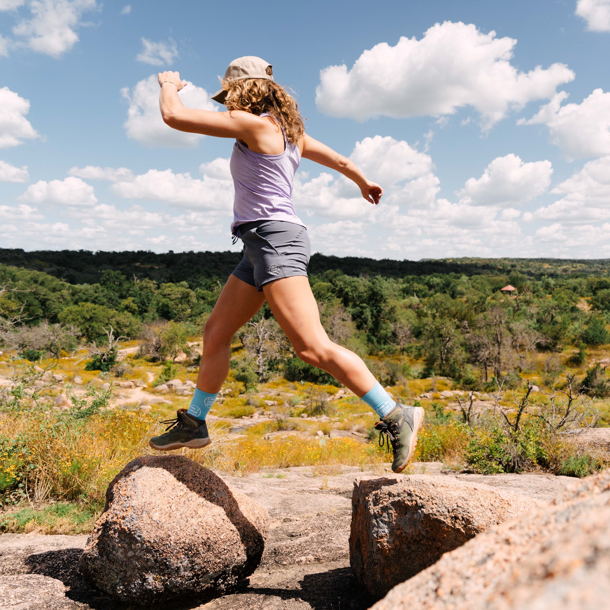 A woman wearing LIVE A GREAT STORY gray active women's shorts while outside