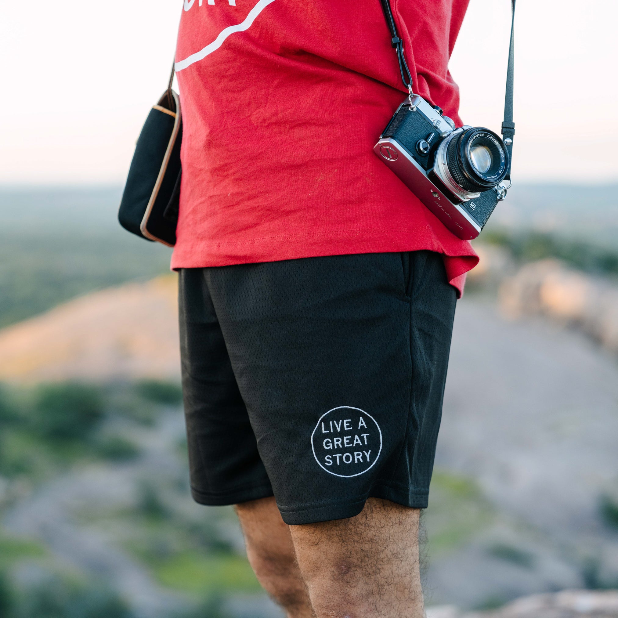 A man wearing black LIVE A GREAT STORY Men's Summer Shorts while outdoors