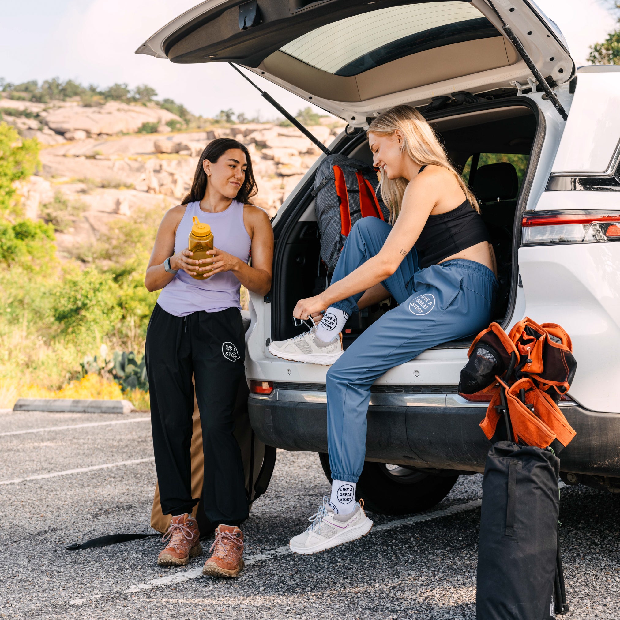 A lifestyle image of two woman wearing LIVE A GREAT STORY athletic jogger pants