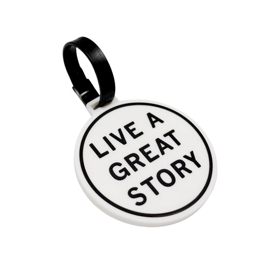 A closeup of a LIVE A GREAT STORY luggage tag