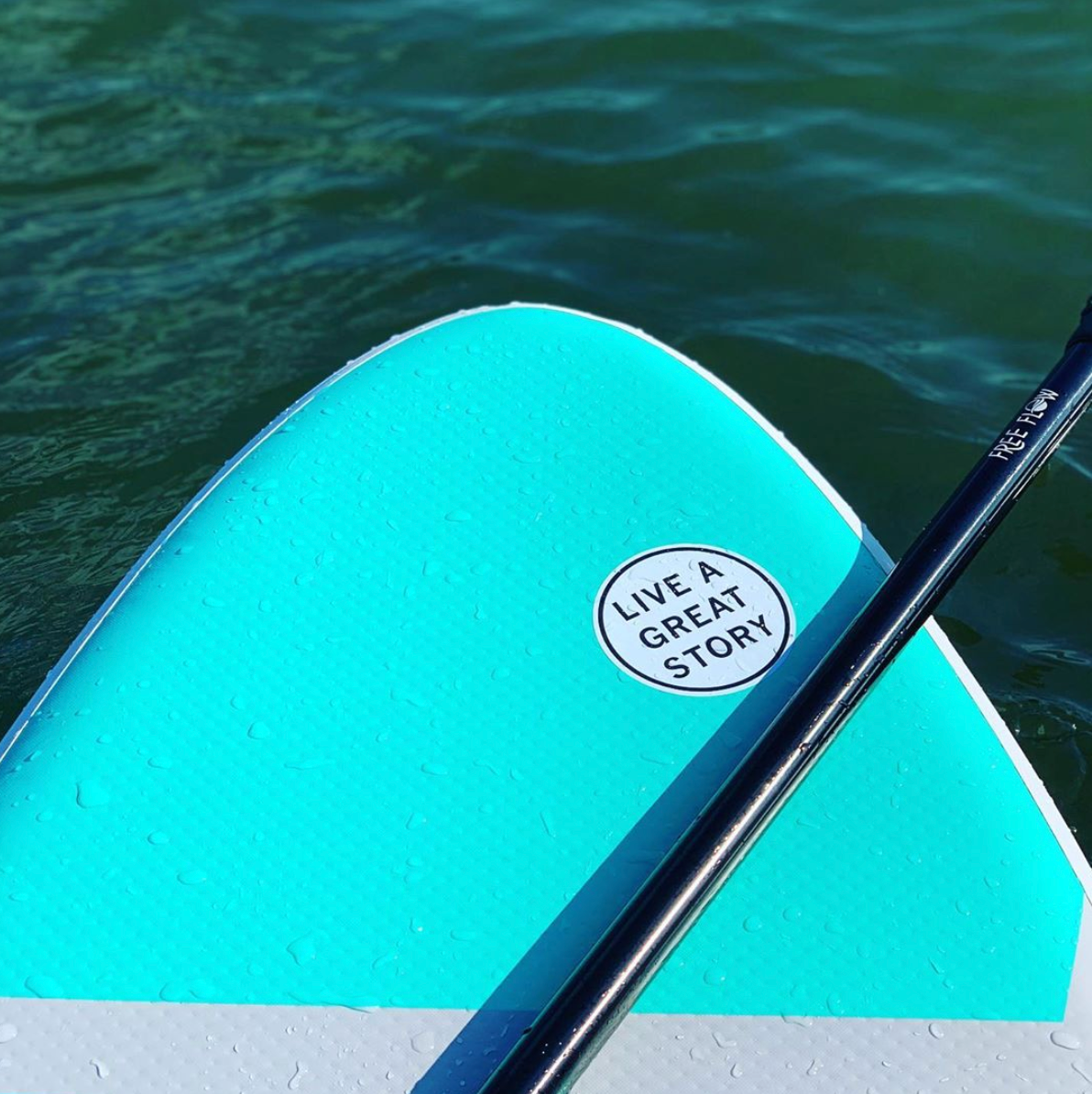 A LIVE A GREAT STORY Inspirational Sticker on a paddle board